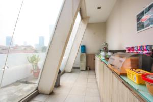 una cucina con bancone e una finestra in una stanza di LeGreen Suite Poso a Giacarta