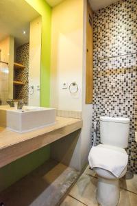 un bagno con un water bianco e un lavandino di LeGreen Suite Poso a Giacarta Altre 10 foto