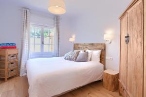 a bedroom with a large white bed and a window at Villa Anna in Begur +55 photos