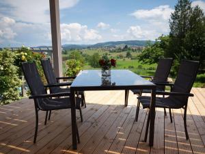 a table and chairs on a deck with a view at Ferienwohnungen beim Wohlfühlhaus Freiamt in Freiamt