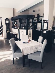 comedor con mesa, sillas y reloj en Pensiunea Iris en Sighetu Marmaţiei