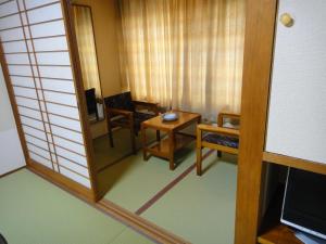 a room with a wooden table and a mirror at Kisoya in Gero