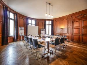 una sala conferenze con un lungo tavolo e sedie di Mercure Le Mans Centre a Le Mans