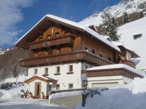 ein Haus im Schnee mit einem Berg in der Unterkunft Apartmenthaus Innerkratzerhof in Prägraten