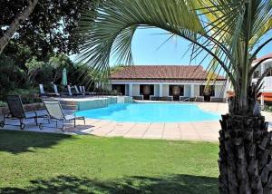 a swimming pool with two chairs and a house at The Dunes Resort 80 & 69 in Plettenberg Bay