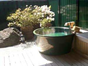 a pot of water is sitting in a garden at Kisoya in Gero