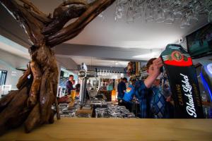 a woman standing at the counter of a bar at Pili Pili Beach Cabanas in Sedgefield