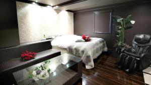 a bedroom with a bed and a table and a window at agehA - Adult Only- in Fukuyama