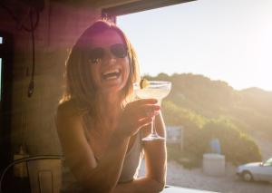 a woman in sunglasses holding a glass of wine at Pili Pili Beach Cabanas in Sedgefield