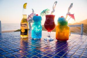 a table with two bottles and two glasses of drinks at Pili Pili Beach Cabanas in Sedgefield
