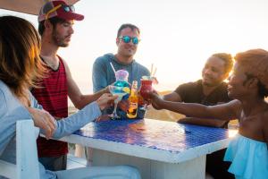 a group of people sitting around a table with drinks at Pili Pili Beach Cabanas in Sedgefield