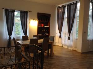 a dining room with a table and chairs and windows at Villa Branco in Taormina