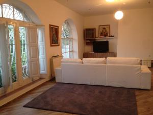 sala de estar con sofá blanco y TV en Villa Branco en Taormina