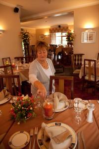 
a woman sitting at a table with plates of food at Hanora's Cottage Guesthouse and Restaurant in Ballymacarbry
