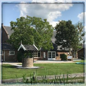 a house with a tree in front of it at Gastenverblijf Rodenburg in Streefkerk