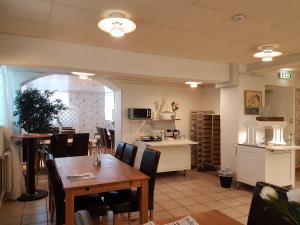 a dining room with a table and chairs and a kitchen at Halmstad Hotell & Vandrarhem Kaptenshamn in Halmstad