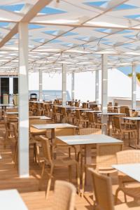 an empty restaurant with tables and chairs at Torre Cintola Greenblu Sea Emotions in Monopoli