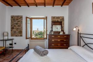 una camera con letto, cassettiera e finestra di Casa Vignolo a Montalcino