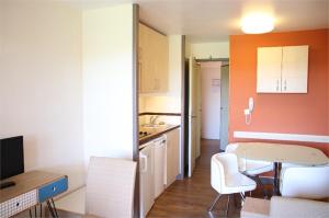 eine kleine Küche mit einem Tisch und Stühlen in einem Zimmer in der Unterkunft CAP ESTEREL appartement climatisé dans le centre du village vacances in Drammont