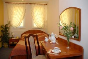 a bedroom with a bed and a table with a mirror at Hotel Kaukaska in Wolsztyn