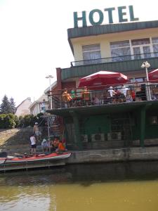 een boot geparkeerd naast een hotel op het water bij Hotel Kaukaska in Wolsztyn