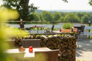 a patio with tables and chairs and a stone wall at Berghotel Hohe Mark in Reken