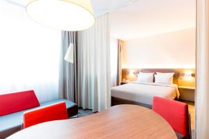 a hotel room with two beds and a table at Novotel Suites Genève Aéroport in Geneva