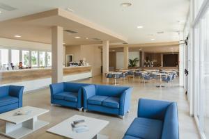 a lobby with blue chairs and tables and a bar at Torre Cintola Greenblu Sea Emotions in Monopoli
