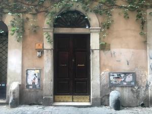 ローマにあるレジデンツァ ドミツィアの茶色の扉が目の前にある建物