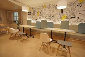 a restaurant with two tables and chairs and a mural at Nomaden Urban Stay in Semarang