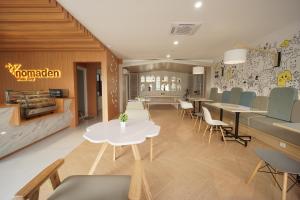 a restaurant with tables and chairs and a cafeteria at Nomaden Urban Stay in Semarang