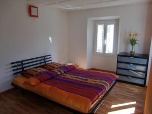 Un dormitorio con una cama y una cómoda y una ventana. en Appartamento via Luina, en Airolo