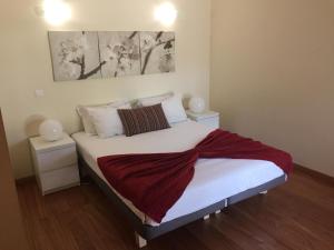 ein Schlafzimmer mit einem Bett mit einer roten Decke darauf in der Unterkunft Villa Jackson in Vilamoura