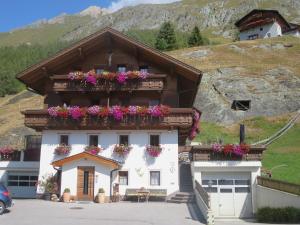 ein Gebäude mit Blumen auf dem Balkon in der Unterkunft Apartmenthaus Innerkratzerhof in Prägraten