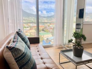 a living room with a couch and a large window at Urban Oasis at Perspectives in Cape Town