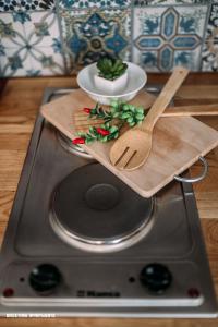 a cutting board with a plate and a spoon on a stove at Brickyard Apartments Cluj in Cluj-Napoca