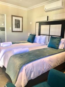 two large beds with blue pillows in a room at The Clan Guest House in Maseru