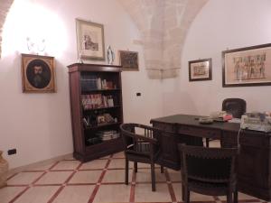 アヴェトラーナにあるVilla Degli Uliviのテーブルと椅子、本棚が備わる部屋