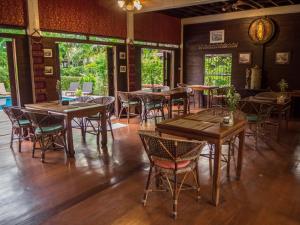a dining room with wooden tables and chairs at Baan Orapin in Chiang Mai