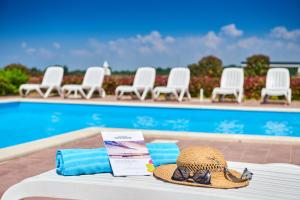een hoed en handdoeken op een tafel naast een zwembad bij Superior Mobile Homes in Camping Kastanija in Novigrad Istria