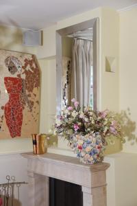 a table with a mirror and a vase with flowers on it at Bubbles & Bed in Bilthoven