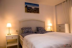 アリカンテにあるCasablancaのベッドルーム1室(ランプ2つ、壁に絵付)