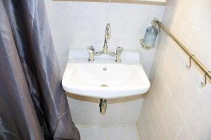 a white sink in a bathroom with a shower at Mia's cozy flat in Ermou, 3 min from "Monastiraki" in Athens