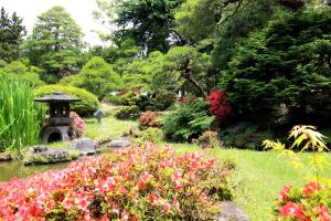 a garden with colorful flowers and a bird bath at Yoshitagawa Bekkan in Higashine