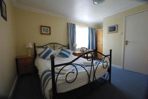 a bedroom with a bed with blue and white pillows at The Sandhill in Sandown