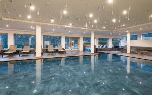 a swimming pool with chairs and tables in a building at Tuberis Life Balance & Nature Farm in Tubre