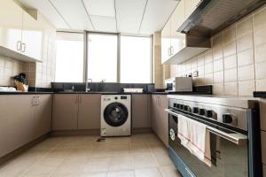 a kitchen with a washing machine and a washer at Blue Ocean Holiday Homes - Polo Residence C1 in Dubai
