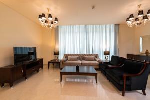 a living room with a couch and a tv at Blue Ocean Holiday Homes - Polo Residence C1 in Dubai