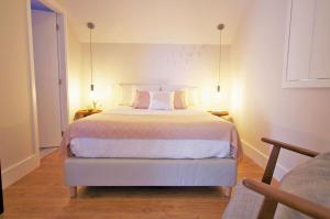 a bedroom with a large white bed with two pillows at Casas do Jardim in Marco de Canaveses