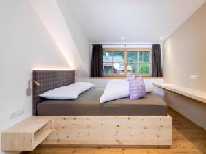 um quarto com uma cama grande e uma janela em Altmessnerhof em Dobbiaco